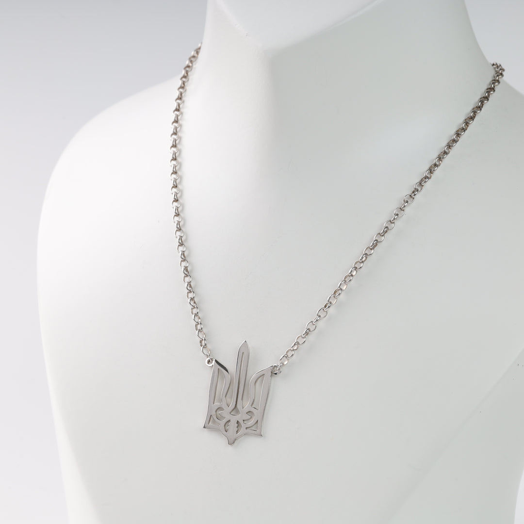 Silver necklace with Ukrainian trident pendant on display bust.