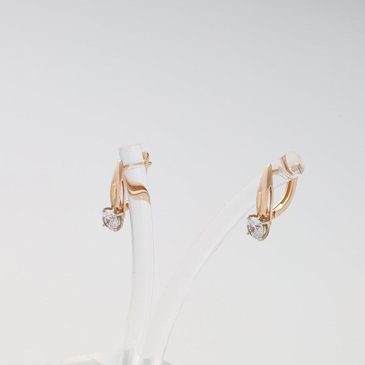 14k gold drop earrings with single clear gemstone studs on display stand, Ukrainian Jewelry, chic gold earrings for women.