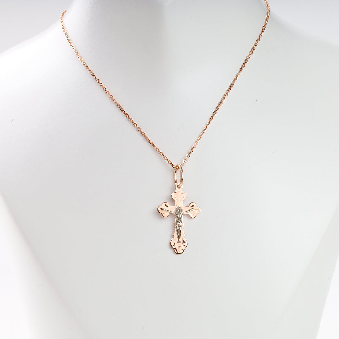 Rose gold chain necklace with a polished cross pendant featuring a silver crucifix, displayed on a white mannequin bust.
