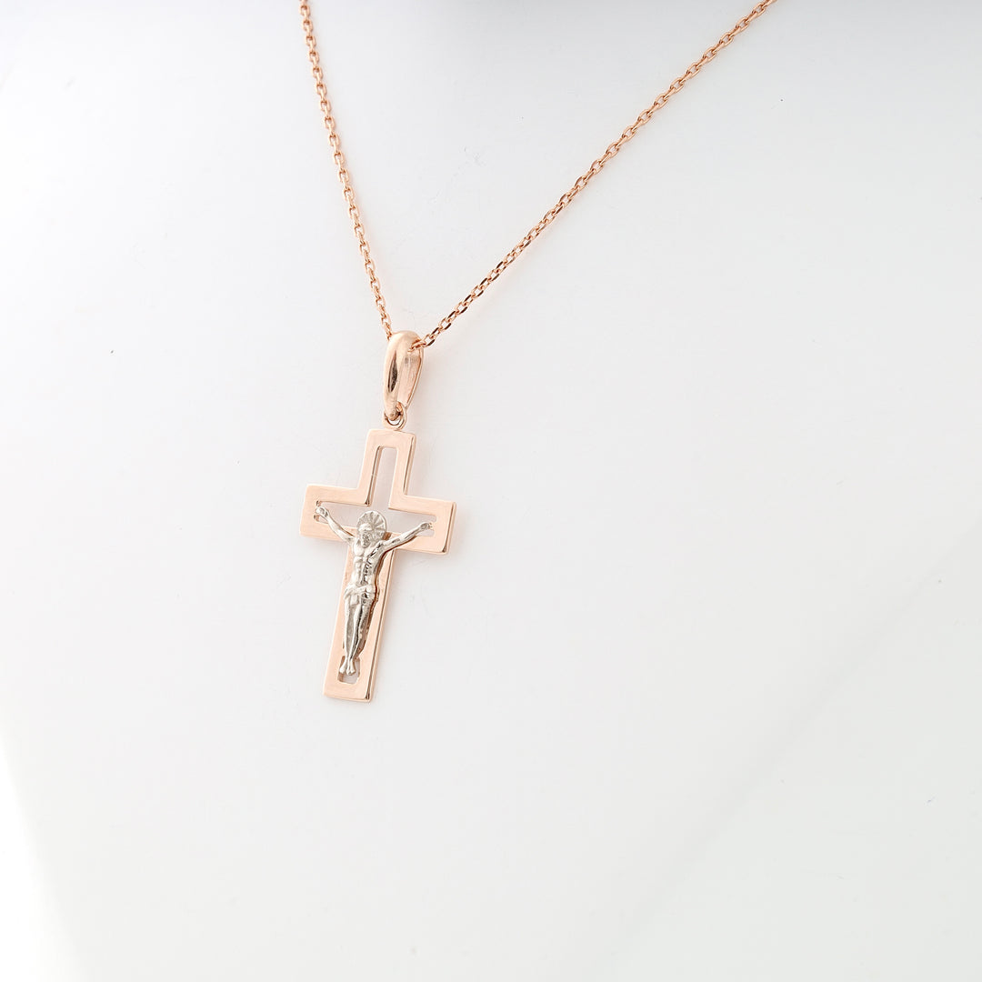 Rose gold crucifix pendant necklace with a silver Jesus figure, shown on a mannequin. Cross necklace, religious jewelry.
