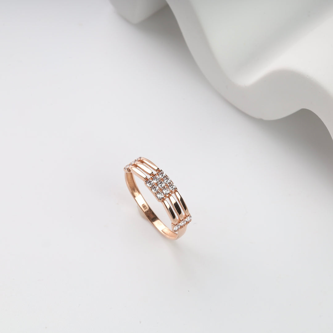 Rose gold ring with a central cluster of small diamonds on a plain white background.