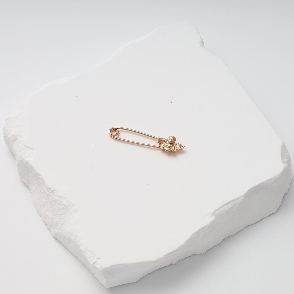 Gold safety pin brooch with small angel charm on white stone display, Ukrainian Jewelry, delicate gold pin brooch gift.