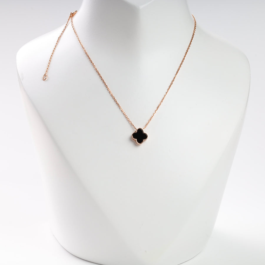 Rose gold necklace with black clover pendant displayed on a white bust.