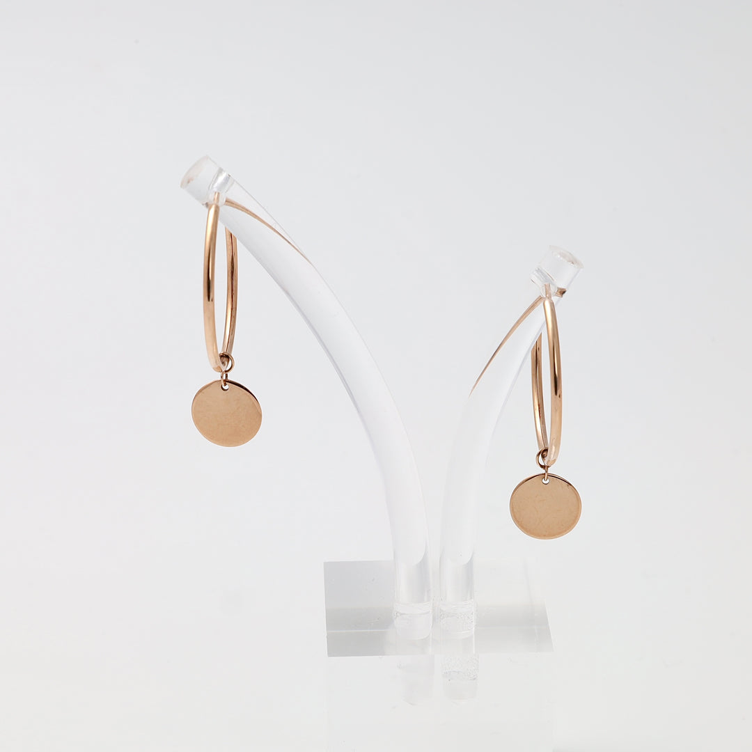 Pair of 14k gold hoop earrings with round disc charms on a clear stand, minimalist dangle Ukrainian Jewelry for everyday wear.