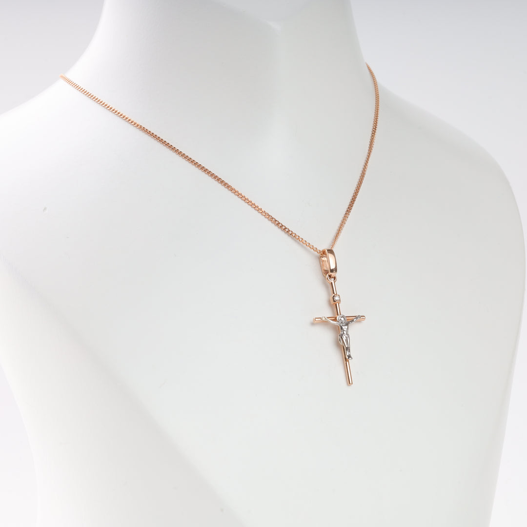 Gold chain necklace with a two-tone crucifix pendant displayed on a white mannequin bust.