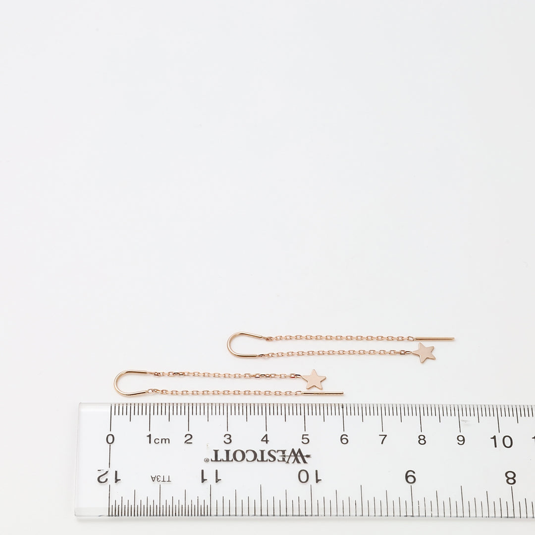 Rose gold star threader 14k gold earrings laid by a ruler, delicate chain pull through style, Ukrainian Jewelry for minimalist earring lovers.