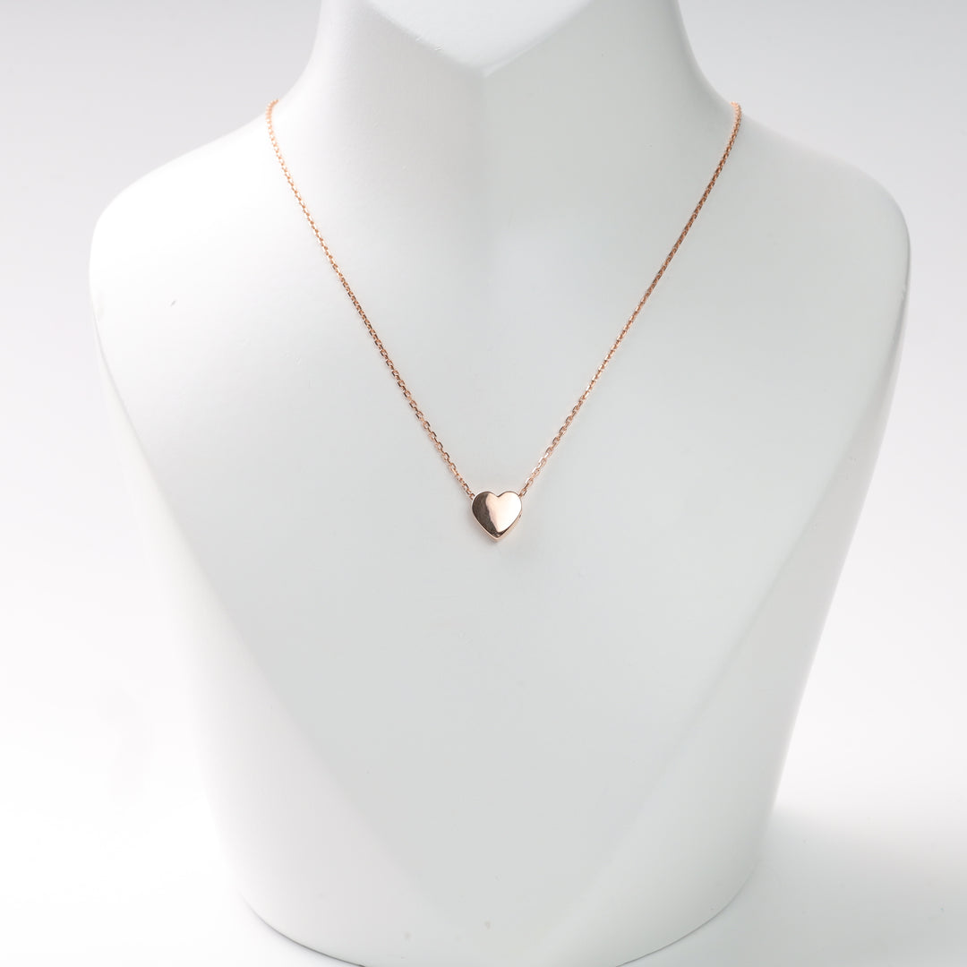 Rose gold heart pendant necklace on a white display bust, rose gold heart necklace, rose gold pendant.