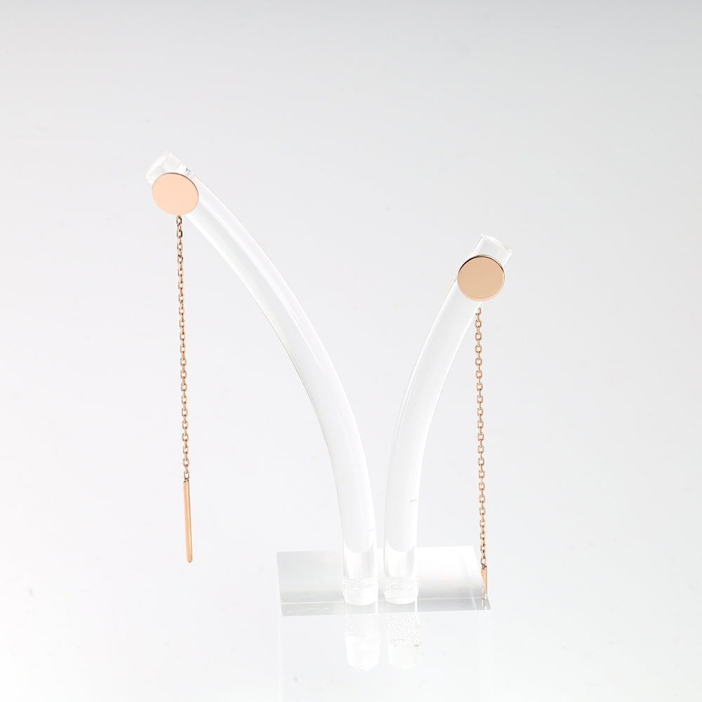 Pair of rose gold chain drop earrings with round studs displayed on a clear stand.