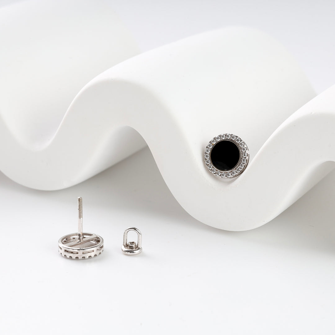 Silver stud earring with a round black stone center and clear rhinestone halo, shown with back and post on a white display.