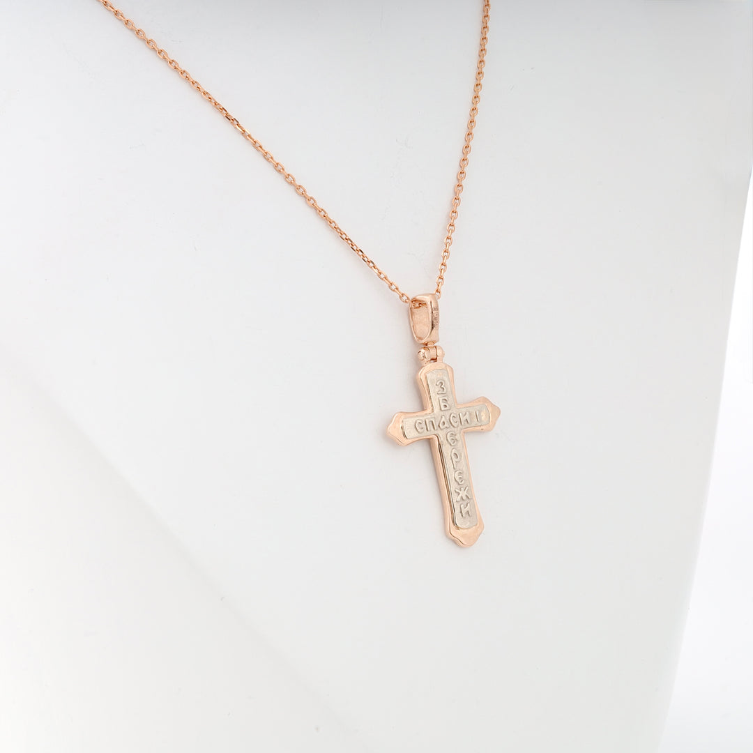 Gold cross necklace with Cyrillic engraving displayed on a white background, religious jewelry, Orthodox cross.