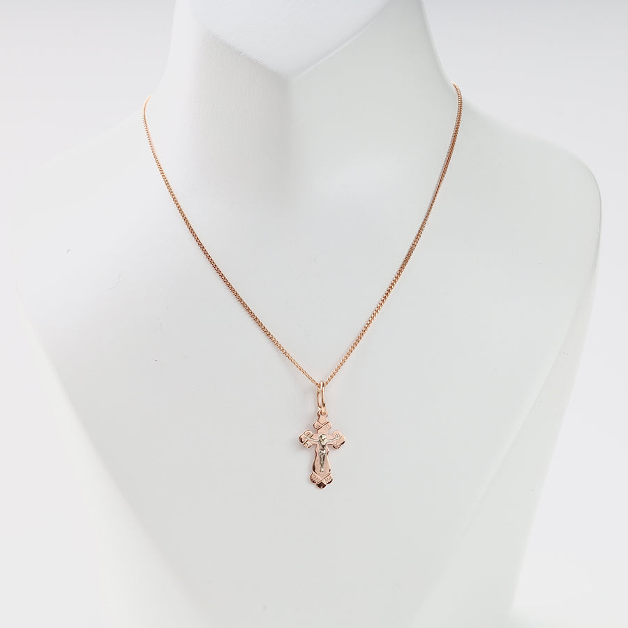 Rose gold chain necklace with a crucifix cross pendant displayed on a white bust for jewelry, religious cross necklace.