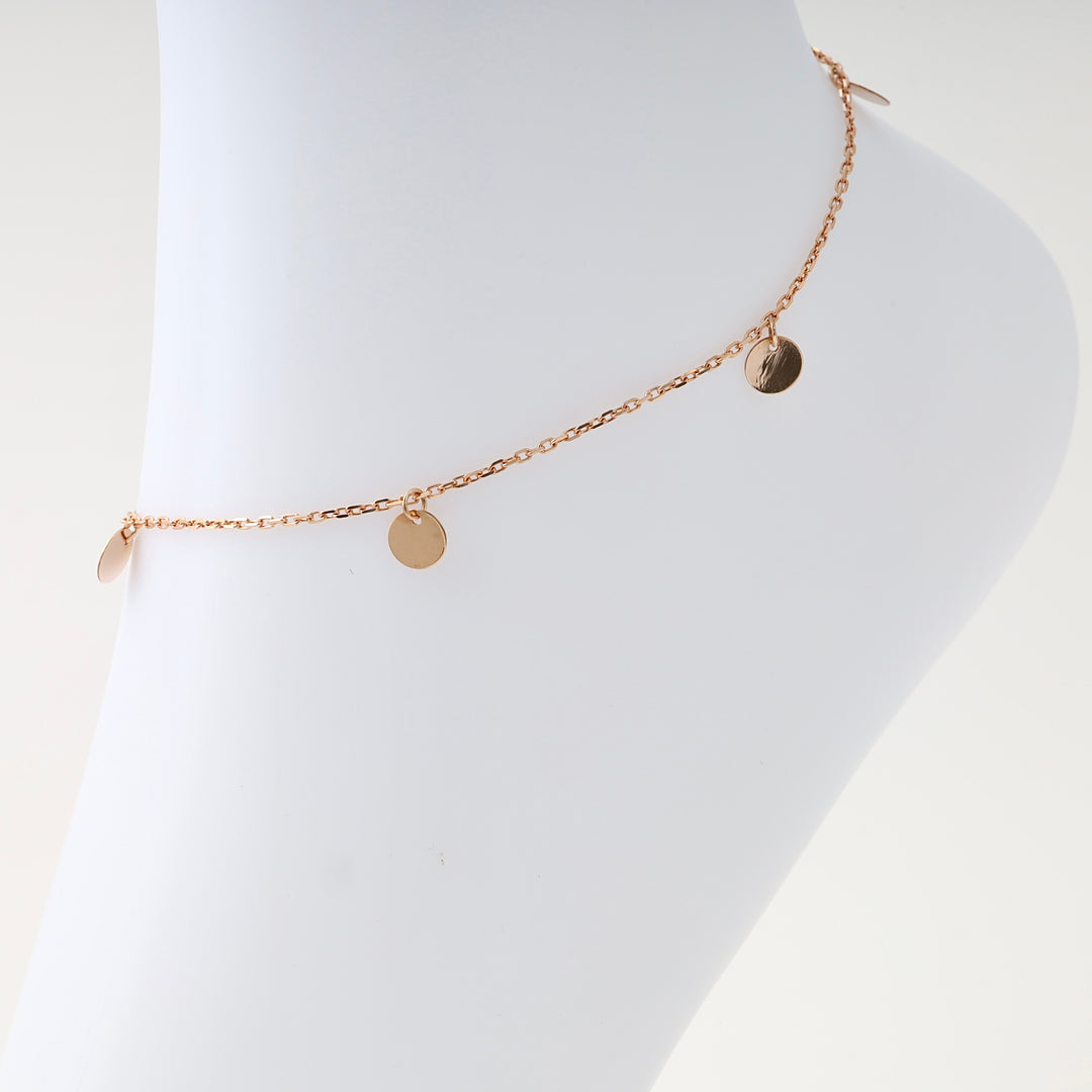 14k gold anklet with small disc charms displayed on a leg, minimalist chain Ukrainian Jewelry for women, gold ankle bracelet.