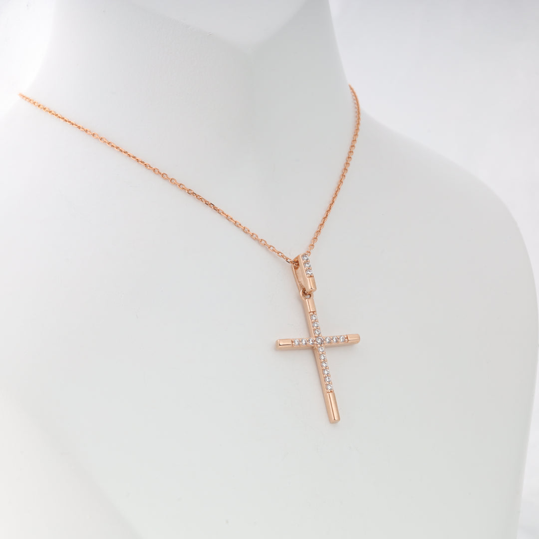 Rose gold cross pendant necklace with clear crystals, displayed on a white mannequin bust.