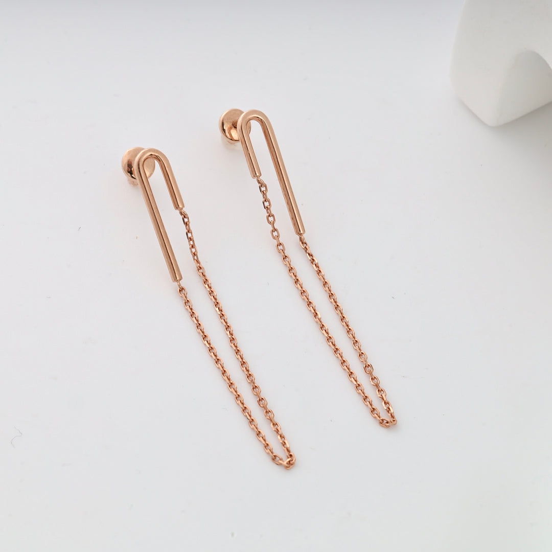 Rose gold dangle earrings with U-shaped hooks and chains.