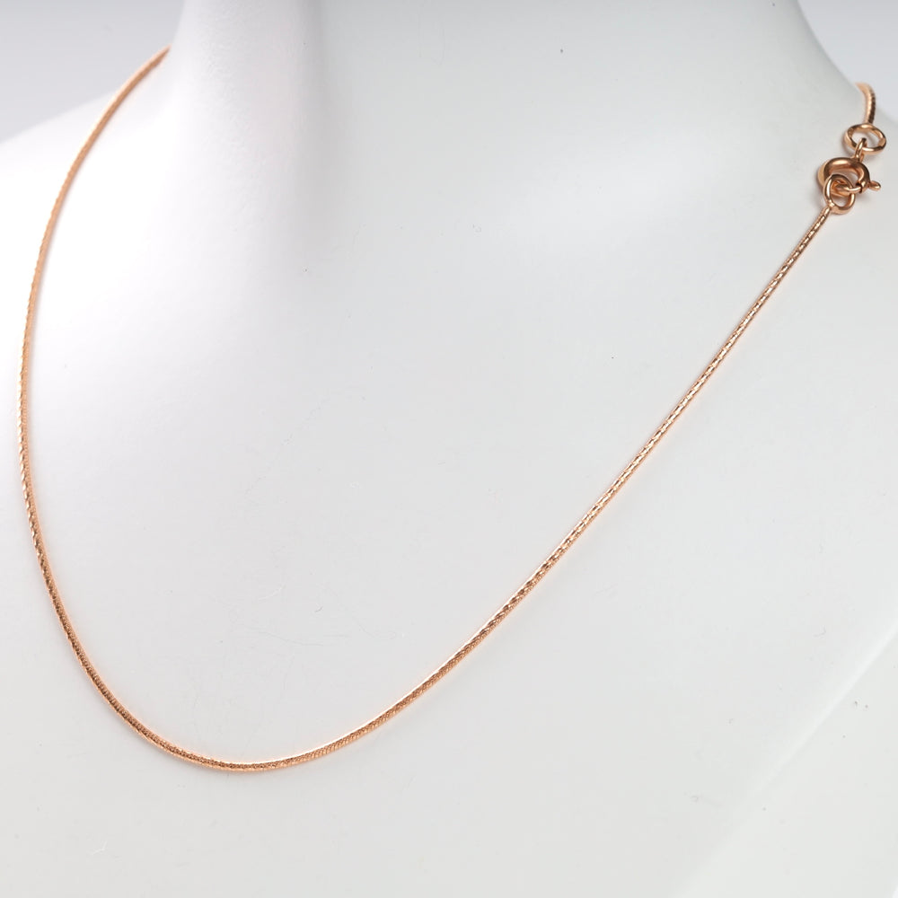 A rose gold chain necklace displayed on a white background.