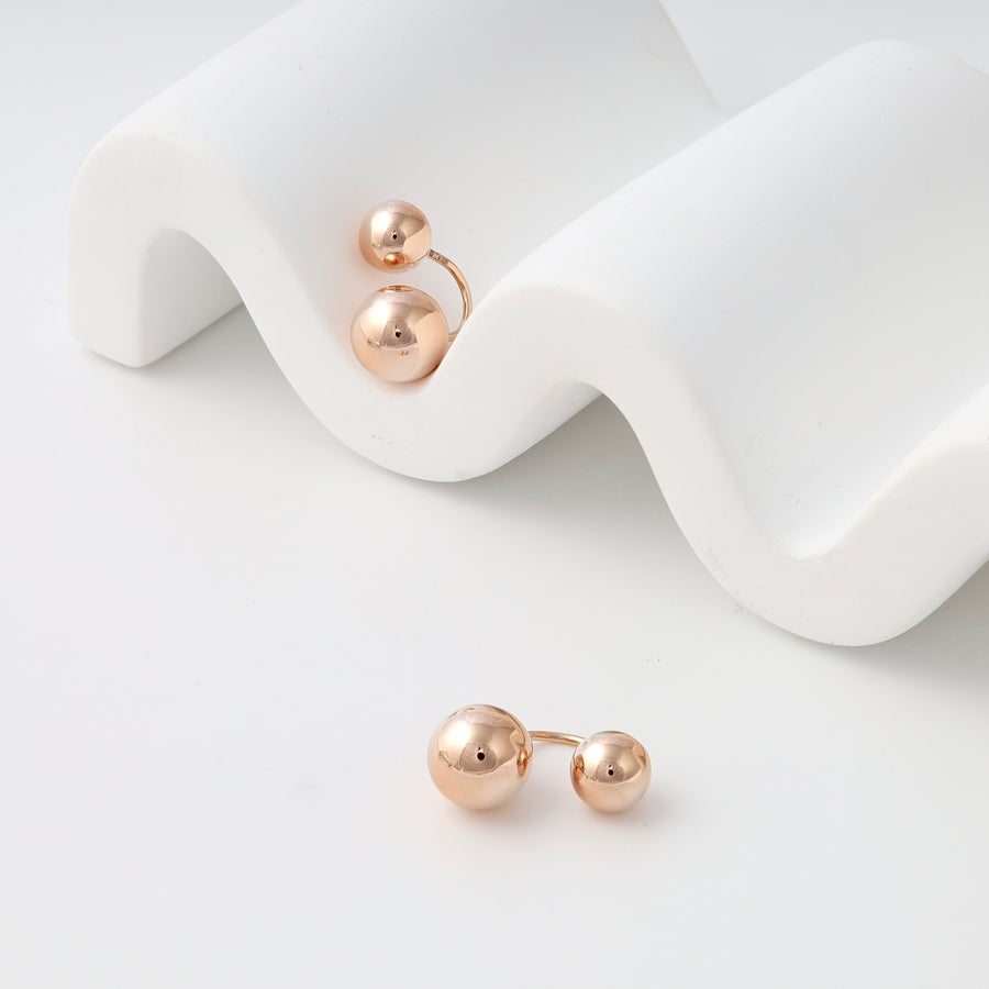 Rose gold double ball 14k gold stud earrings displayed on white waves, minimalist Ukrainian Jewelry for everyday gold earrings shoppers.