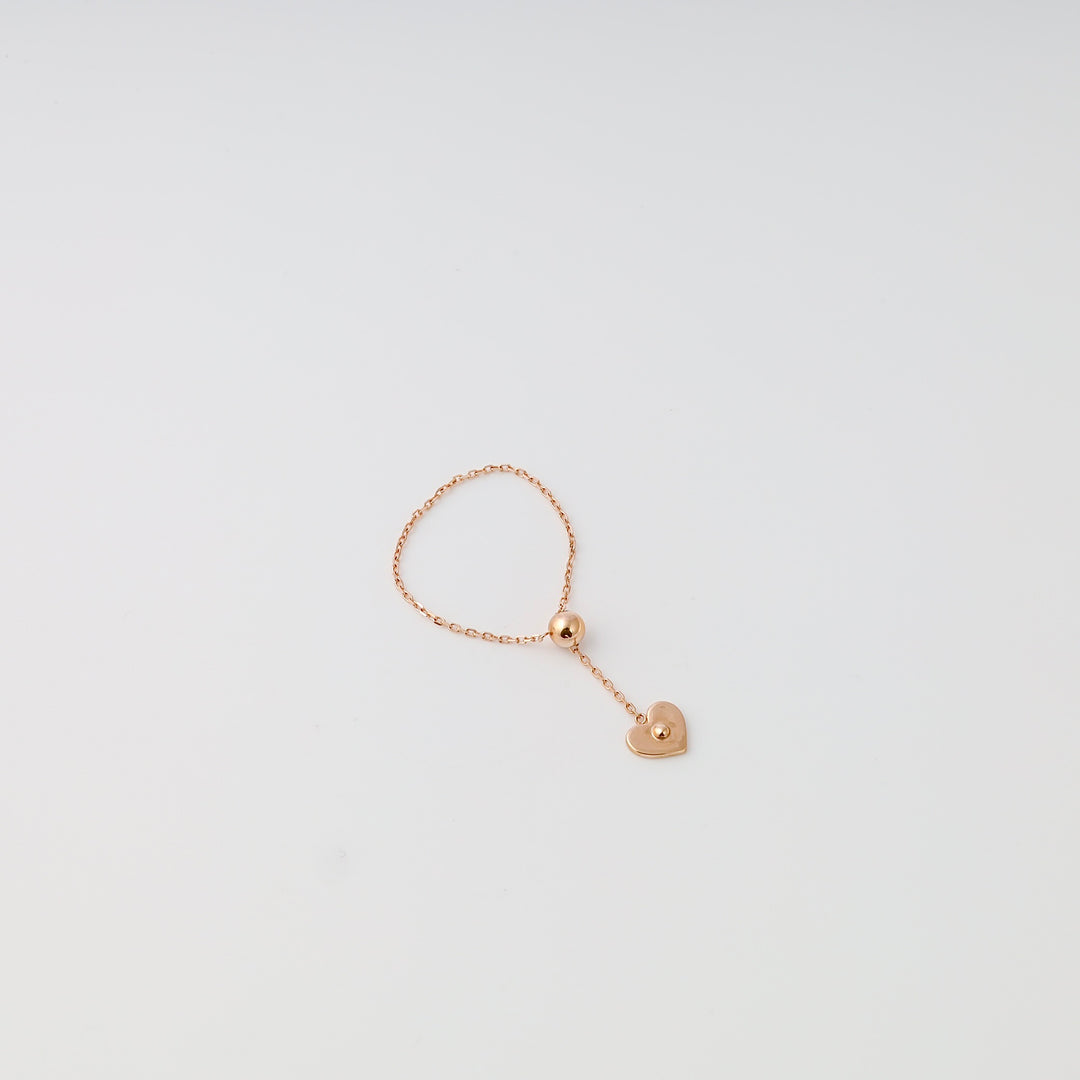 Delicate 14k gold chain ring with dangling heart charm on white background, Ukrainian Jewelry, minimalist gold heart ring.