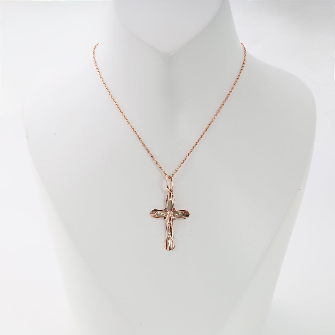 Rose gold cross pendant necklace with Jesus figure, displayed on a white mannequin. Christian jewelry, religious gift.