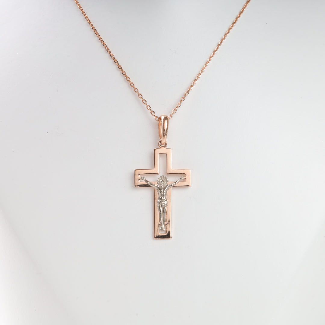 Rose gold crucifix necklace with a silver Jesus figure, shown on a display bust. Cross pendant, religious jewelry.